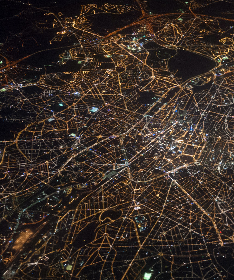 a high view of a city with lights lighting up the grid 